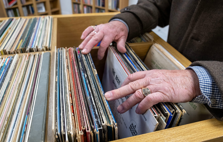 A pair of male hands search through a selection of vintage vinyl