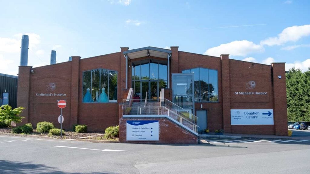 Large warehouse-style shop with staggered steps up to the electric front doors and a customer lift to the right hand side of the steps.