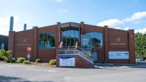 Large warehouse-style shop with staggered steps up to the electric front doors and a customer lift to the right hand side of the steps.