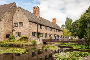 A grand building with a bridge spanning a serene pond.