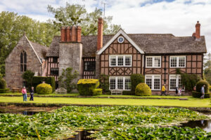 A spacious house with a serene pond in front, creating a picturesque view.