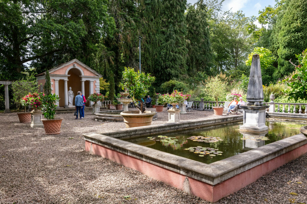 A serene garden featuring a beautiful fountain and an elegant statue, creating a tranquil atmosphere.