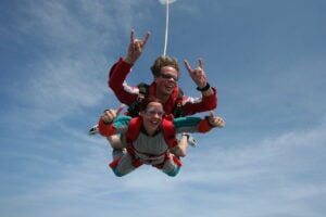 Two people on a tandem skydive free-falling through the air