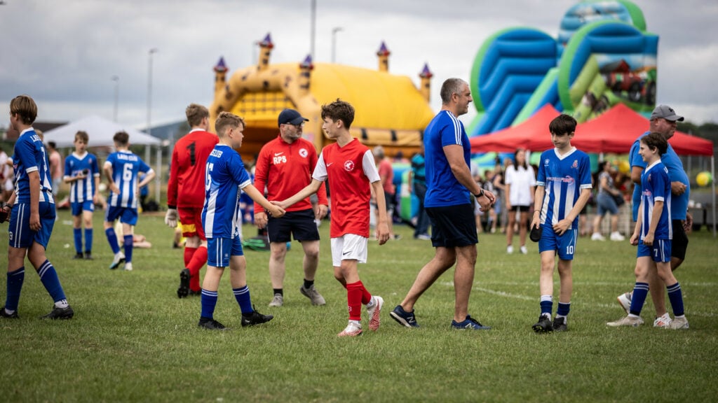 A group of football players shaking hands after the match