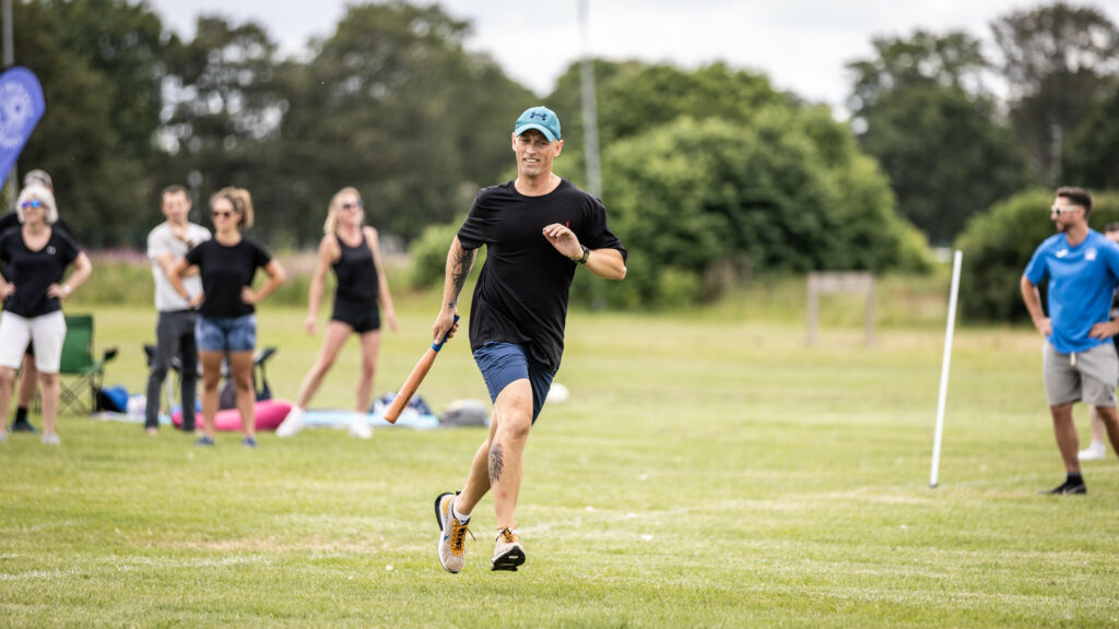 Man running with a bat during a rounders game