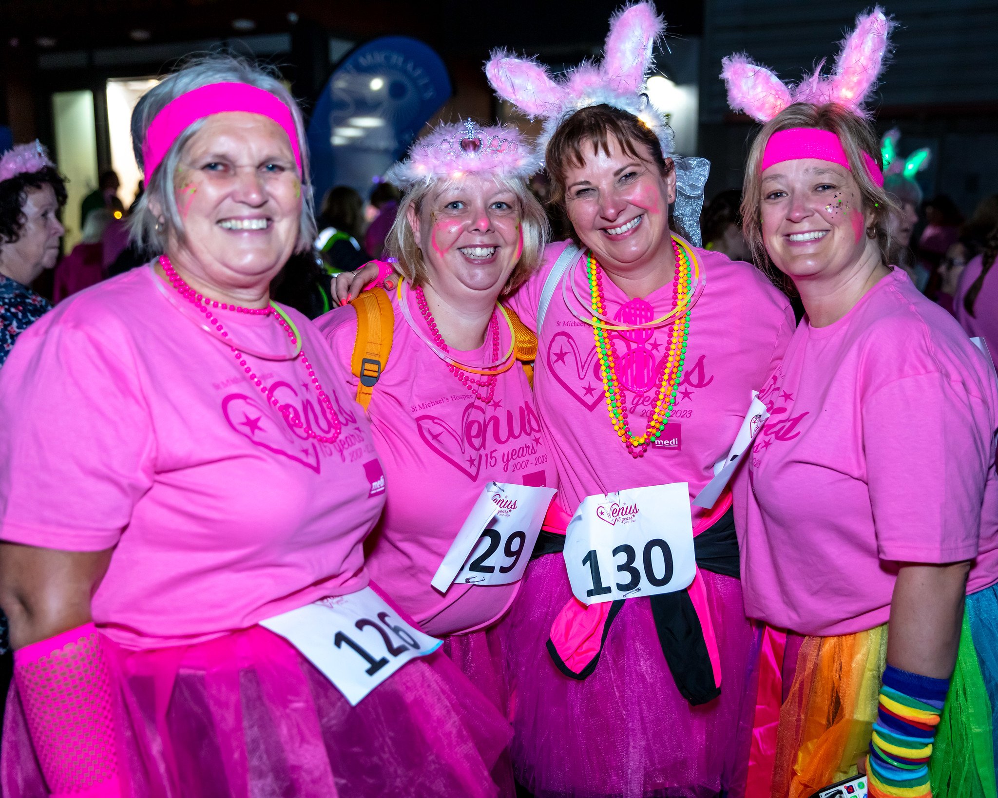 Four women dressed in pink with colourful headbands about to start on the Venus midnight Walk