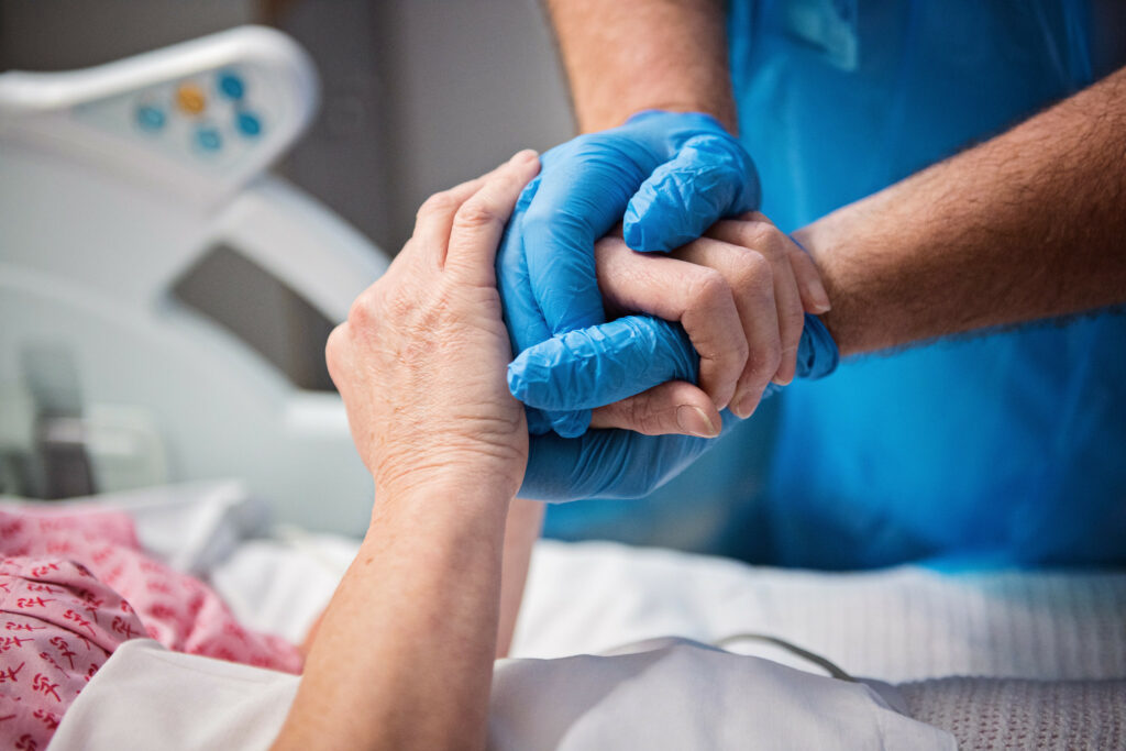 Staff and patient holding hands