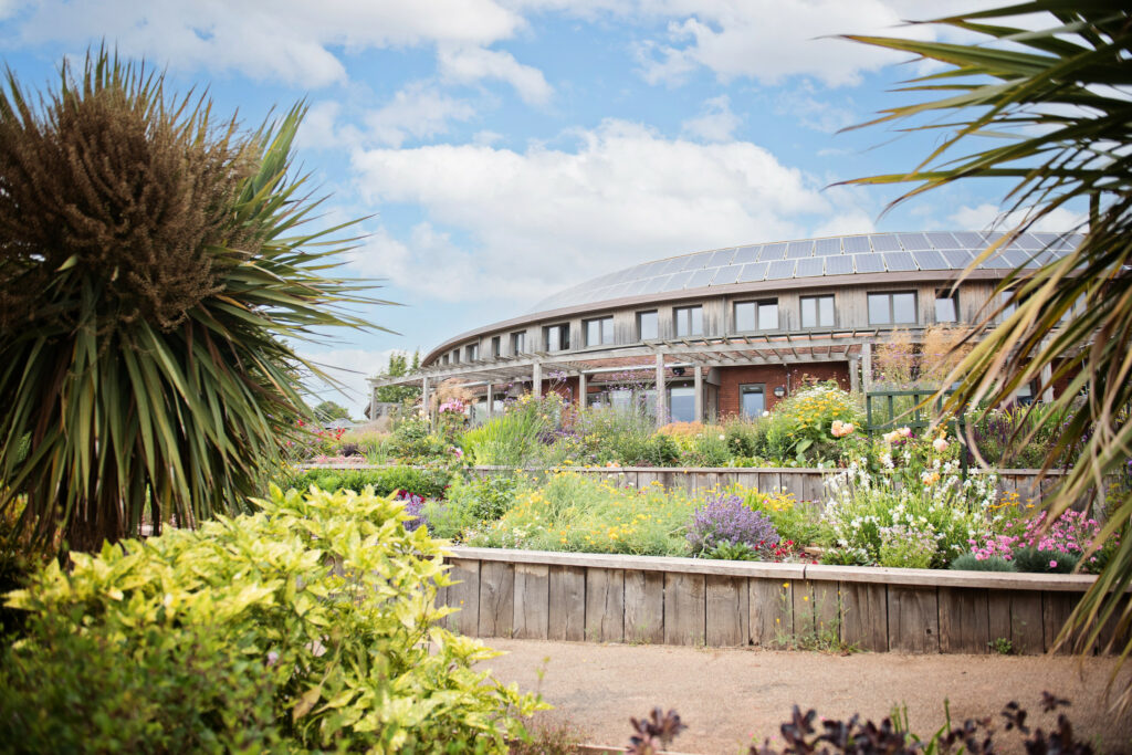 A beautiful structure with a large front garden, set against a clear sky.