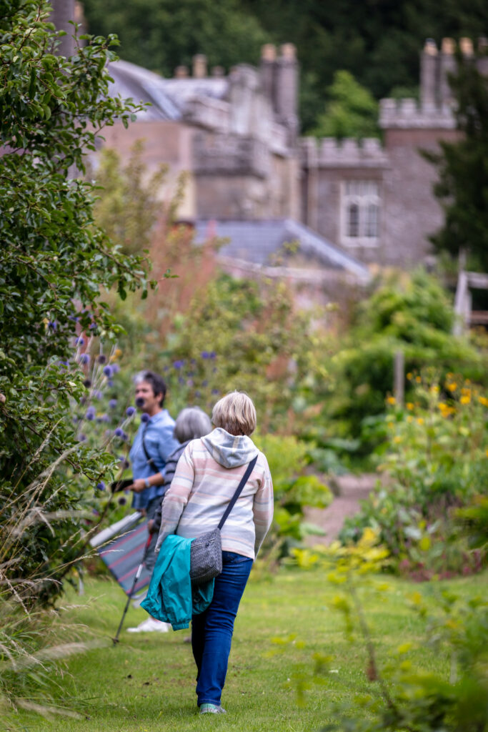 A woman walking with a dog in a park, enjoying a leisurely stroll together.