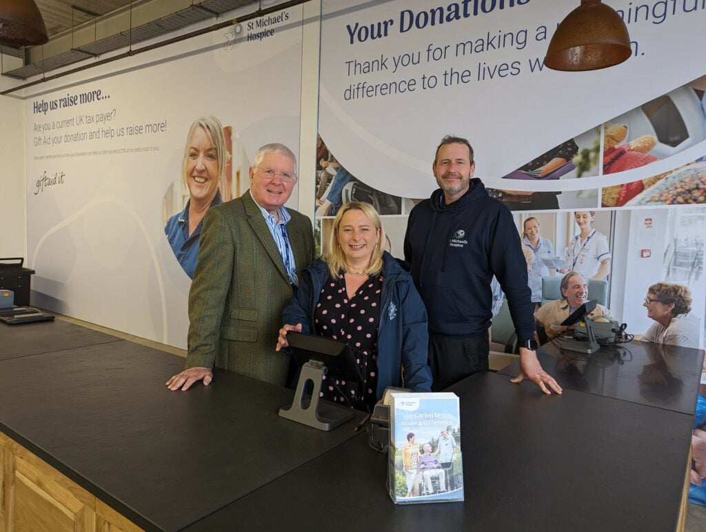 Three SMH staff stand behind the Counter at the opening of the Whitestone Donation Centre