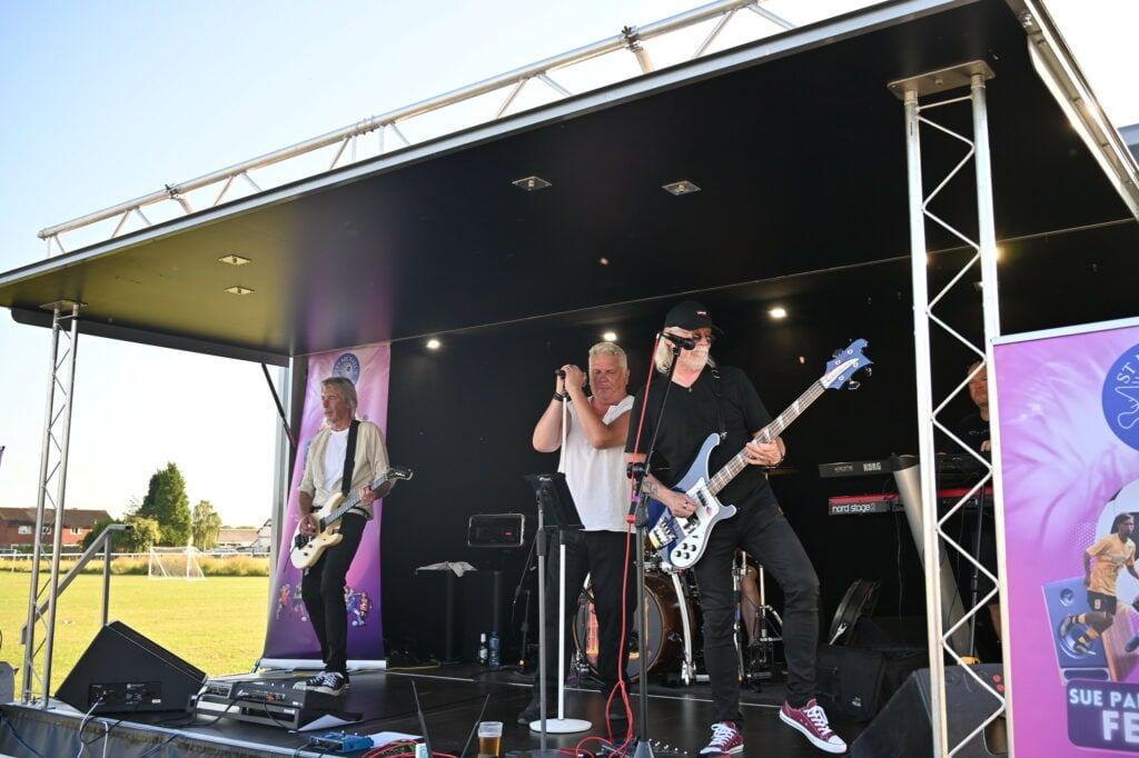Live band entertaining the crowd at an outdoor music festival.