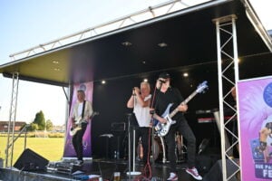 Live band entertaining the crowd at an outdoor music festival.