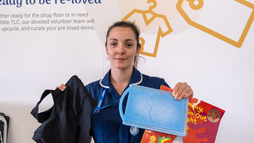 St Michael's Hospice nurse holding up broken and unclean items in the Whitestone donation centre